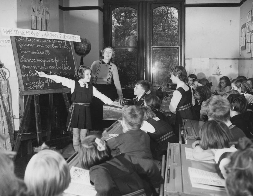 A young girl tutoring her classmates